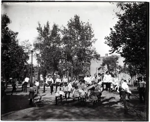 Horizontales, schwarz-weißes Foto von Kindern, die auf Wippen in einem unbekannten Park spielen